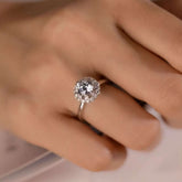 Top view of sunburst baguette halo engagement ring on hand
